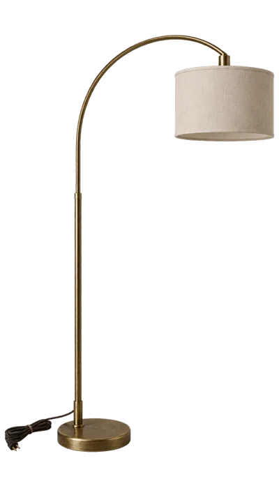 A slim floor lamp with a plain drum shade, switched off, beside a bare wall.