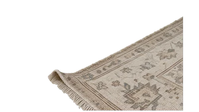 The corner of a flat woven rug turned back on itself.