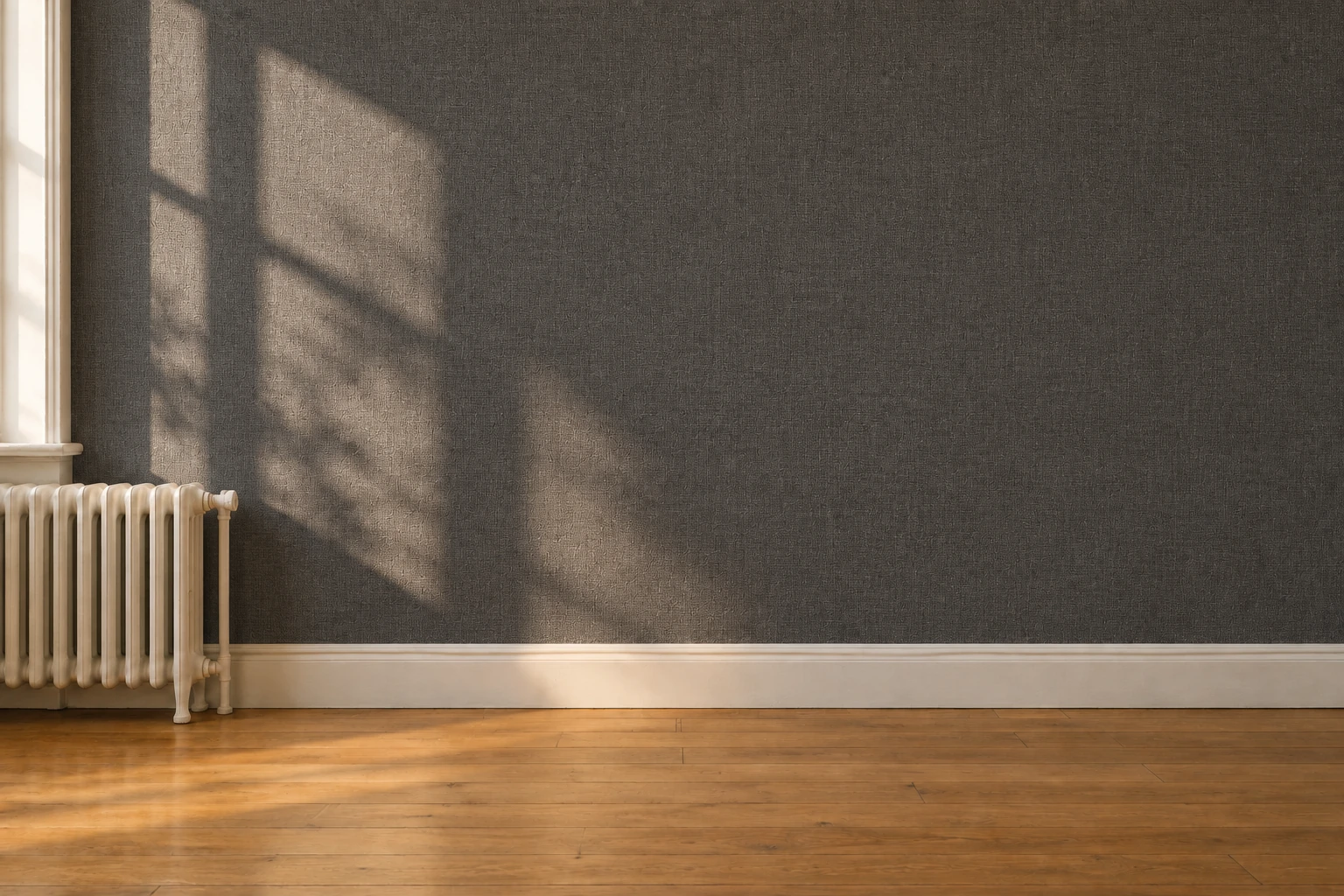A rental wall covered corner to corner in dark charcoal textured peel-and-stick paper, with the radiator and wood floor untouched.