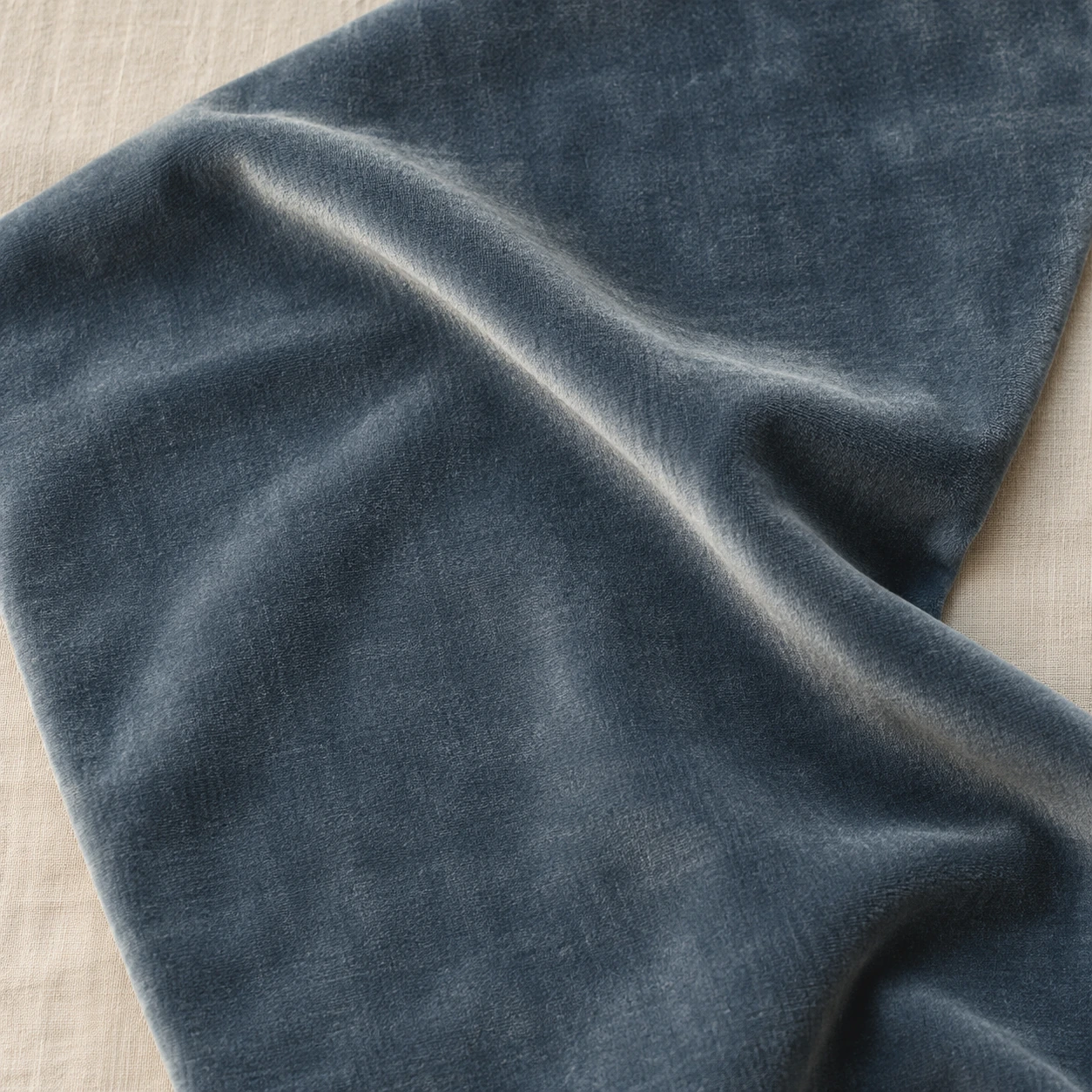 Dusty blue velvet with one deep fold catching the light.