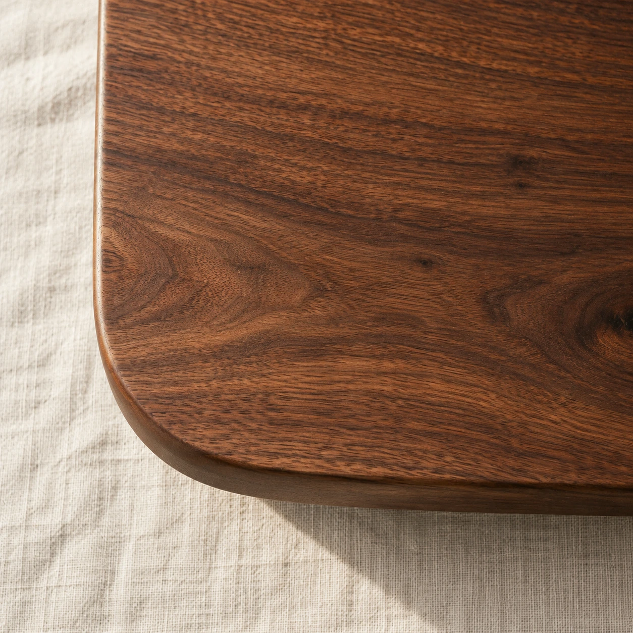 The edge of an oiled walnut tabletop with tight close grain.