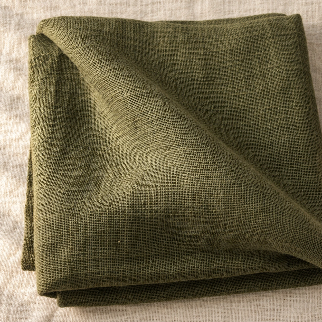 Folded olive linen with the open weave showing.