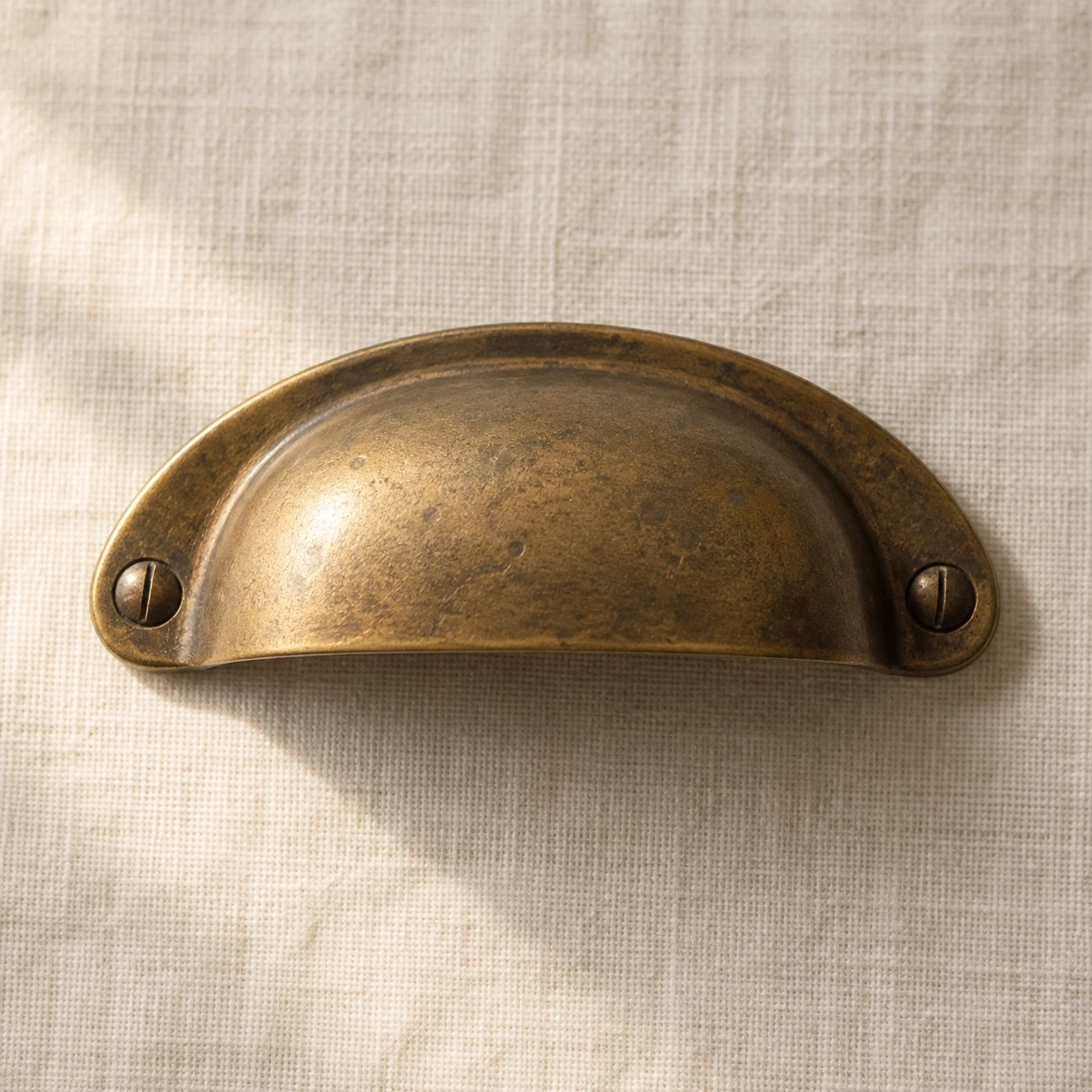 An aged brass object with a matte patina.