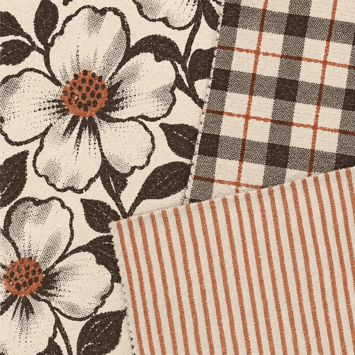 Three completely different fabrics laid overlapping: a large open flower, a check and a fine stripe. Every line of all three is printed in the dark ink except one element in each, which is terracotta: the flower centers, the thin line crossing the check, and the stripe itself.