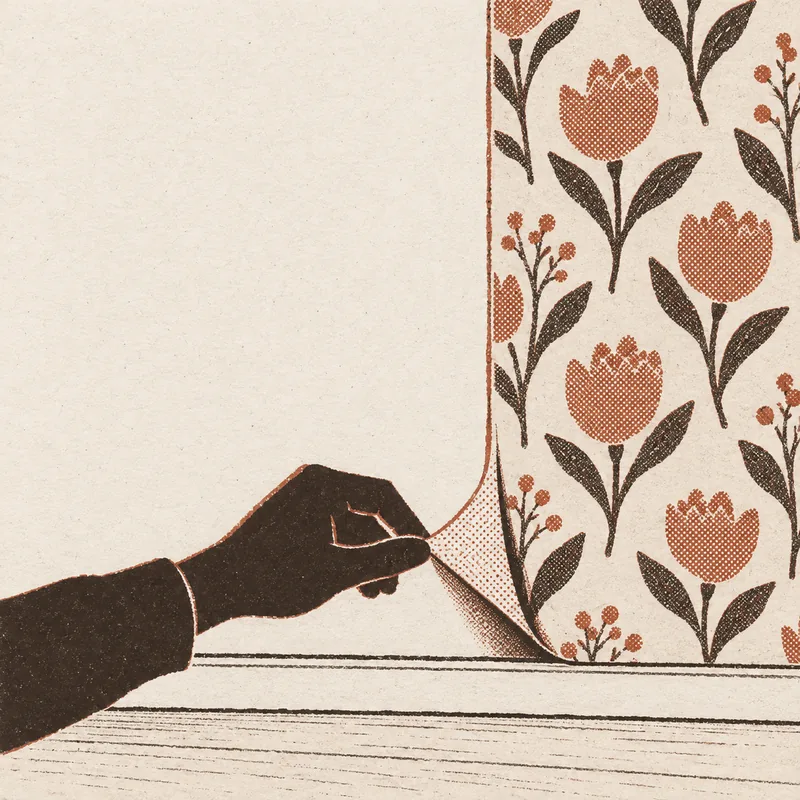 A hand peeling back the bottom corner of a floral peel-and-stick sheet to show the plain wall underneath, tulips and leaves printed on the sheet above.
